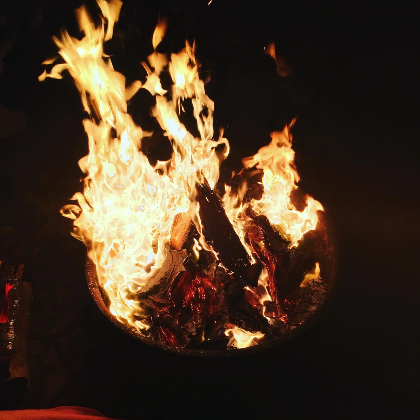 Bright campfire burning at night with flames reaching upward